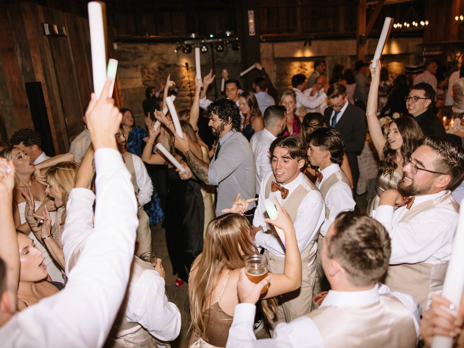 A packed dance floor at The Barns at Cooper Molera, guests mid-song with hands up