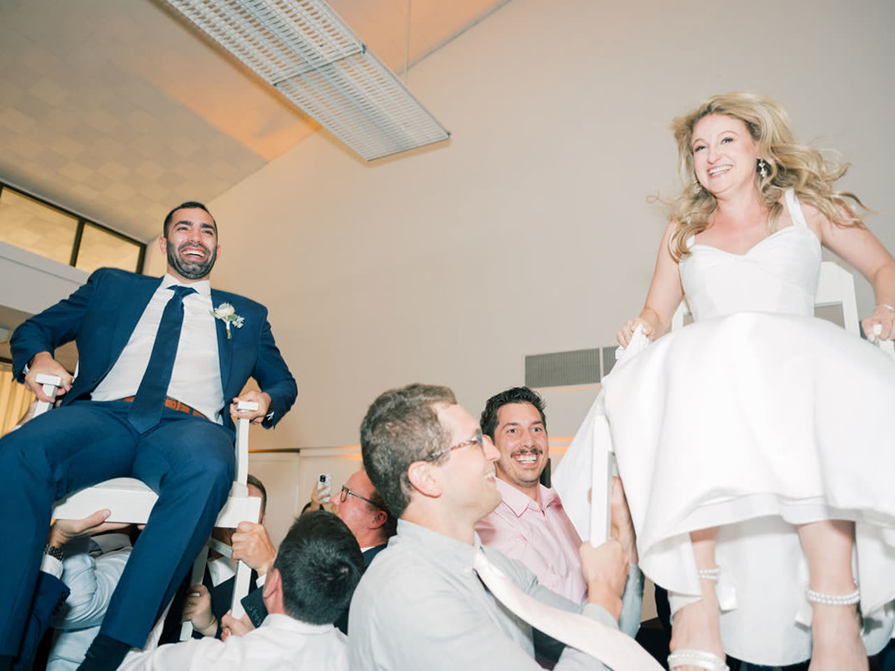 Guests lifting the honorees on chairs during the hora